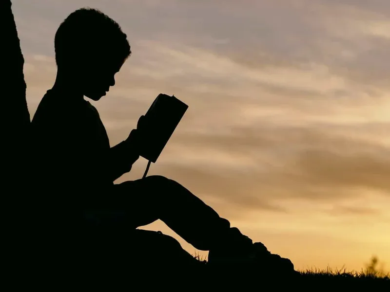 Boy sat under tree reading