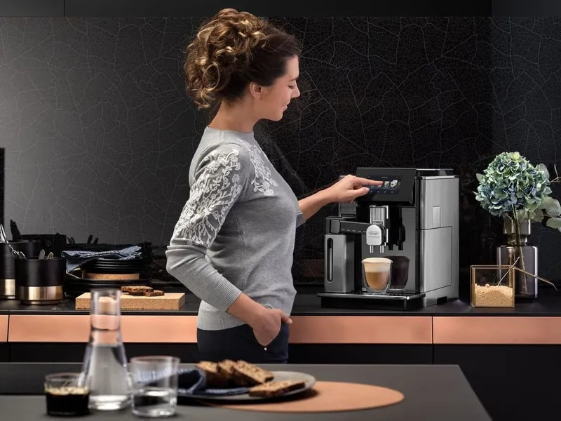 Woman using the top spec De Longhi coffee machine
