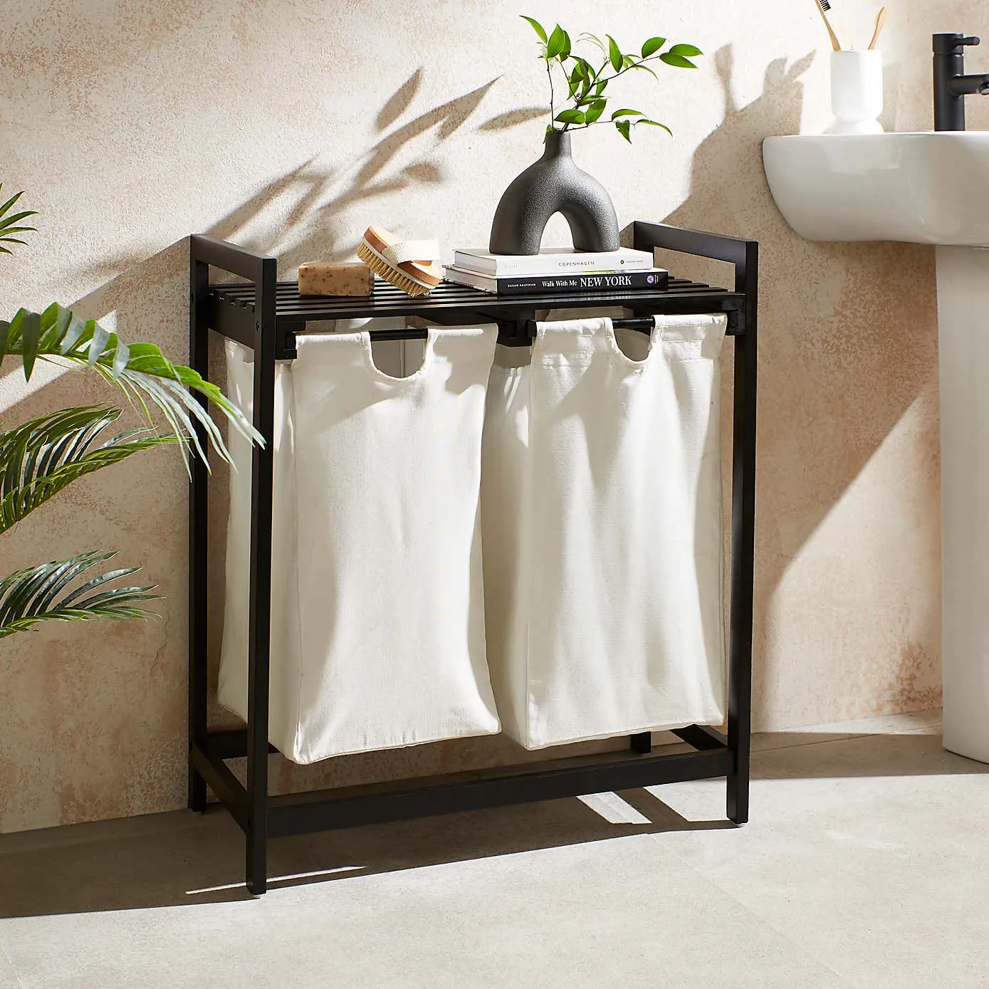 Black frame laundry sorter with two white fabric hampers