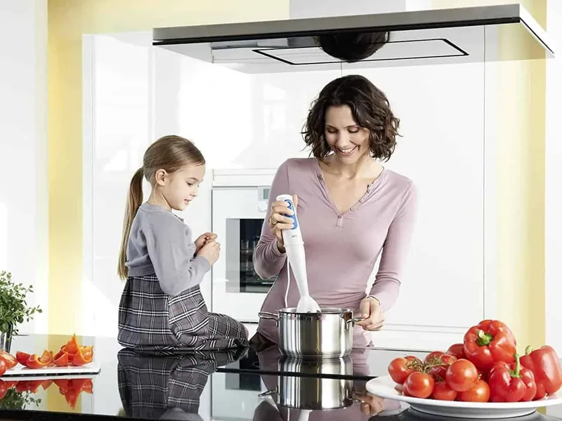 Woman using a hand held blender
