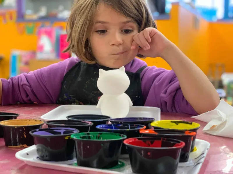 Child painting a model at playschool