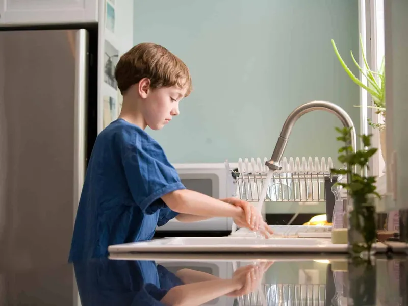Young boy washing his hands