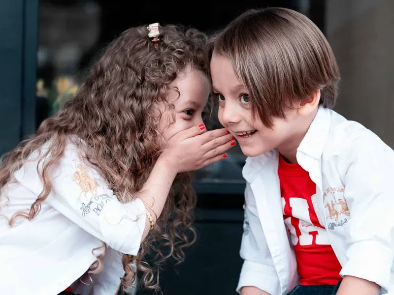 Girl whispering to boy