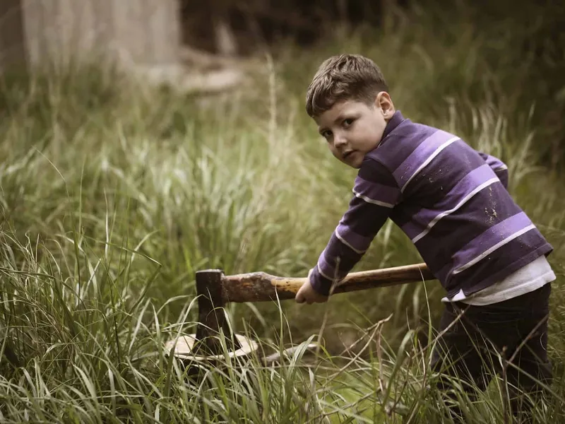 Boy chopping wood with an axe