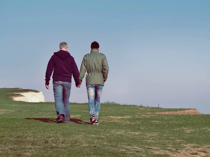 Gay couple walking on cliff top