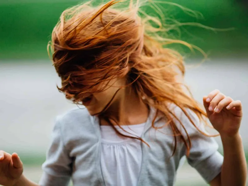 Girl with long red hair dancing