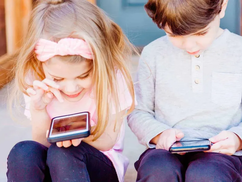 Boy and girl on their mobiles