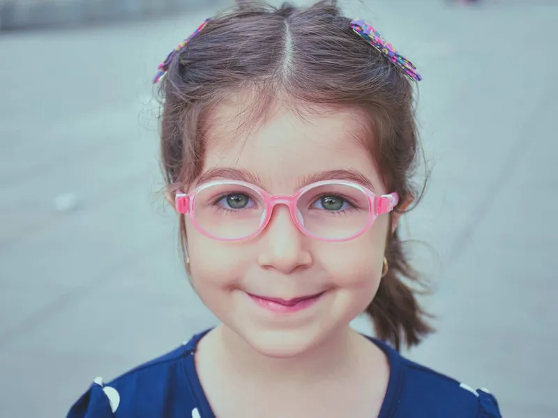 Child wearing pink glasses