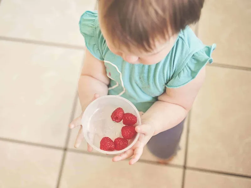 Toddler with a bowl of fruit