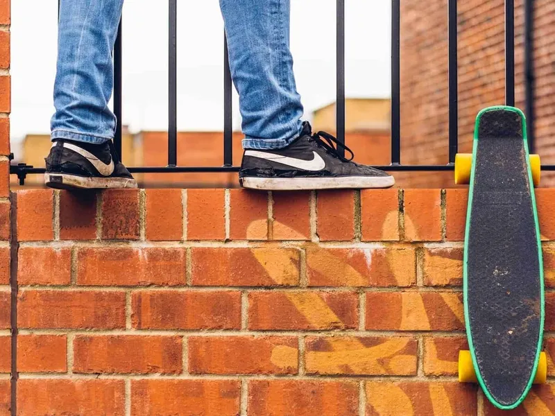Child stood on wall with skateboard