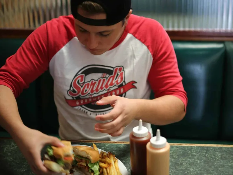 Teenager eating a burger and fries
