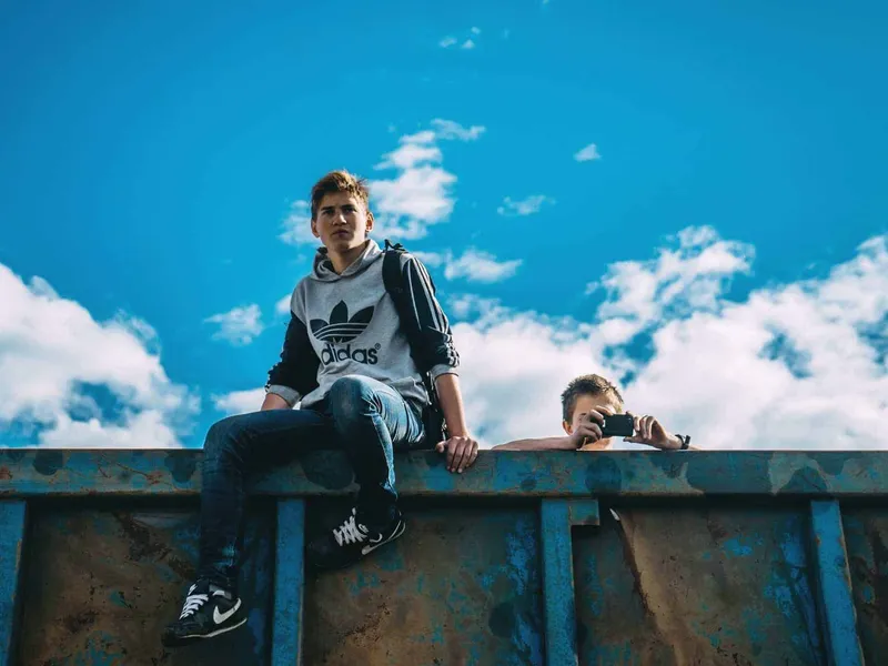 Teenage boy sat on wall